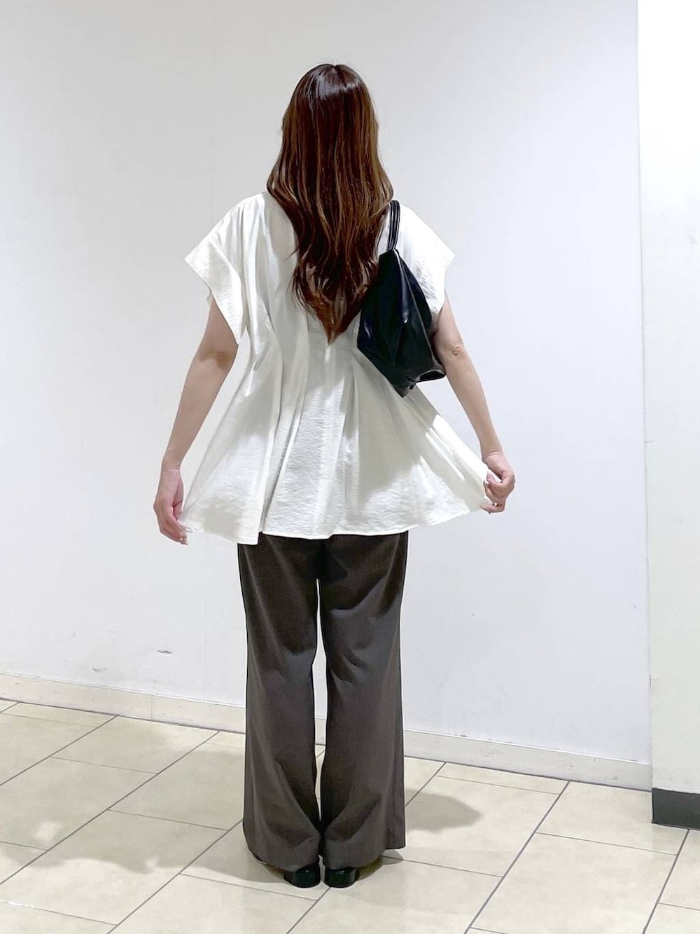 ホワイト系のシャツ/ブラウス、ブラック系のショルダーバッグ、ブラック系のパンプスを着用したレディースの春コーディネートの4枚目の写真