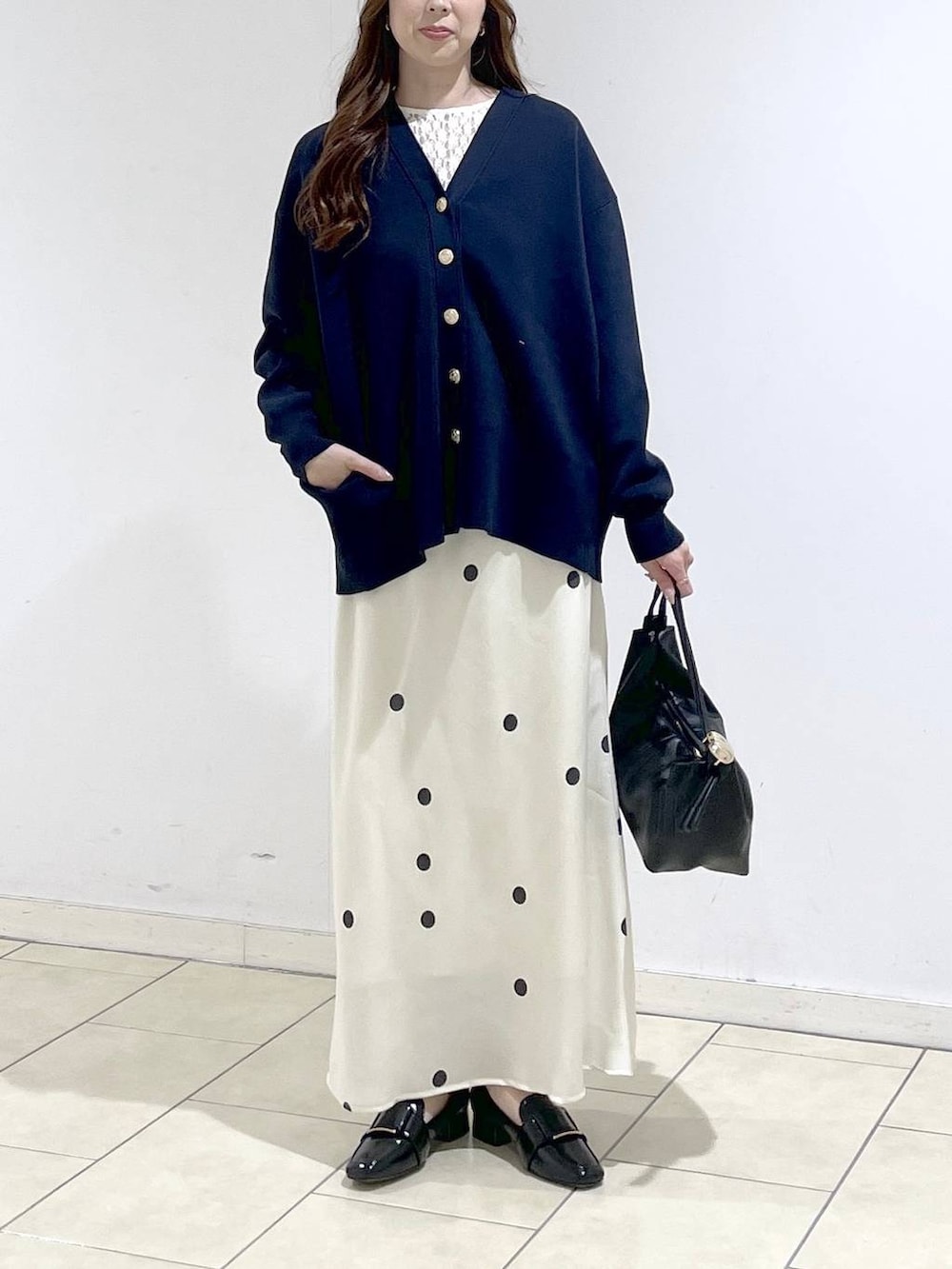 ブルー系のカーディガン/ボレロ、ホワイト系のTシャツ/カットソー、ブラック系のショルダーバッグを着用したレディースの春コーディネートの2枚目の写真