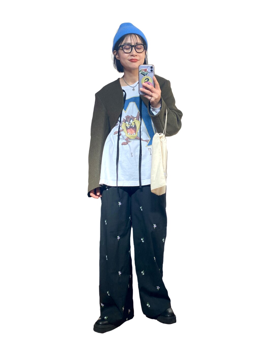 グリーン系のその他アウター、ホワイト系のTシャツ/カットソー、ブラック系のスラックスを着用したレディースの秋コーディネートの2枚目の写真