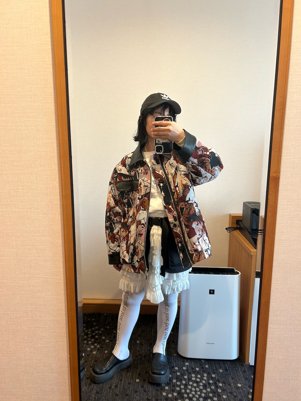 ブラック系のボディバッグ/ウエストポーチ、ホワイト系のスカート、ブラック系のその他シューズを着用したレディースの冬コーディネートの2枚目の写真