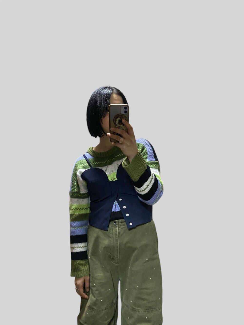 グレー系のその他アウター、ブルー系のベスト、グリーン系のその他パンツを着用したレディースの冬コーディネートの2枚目の写真