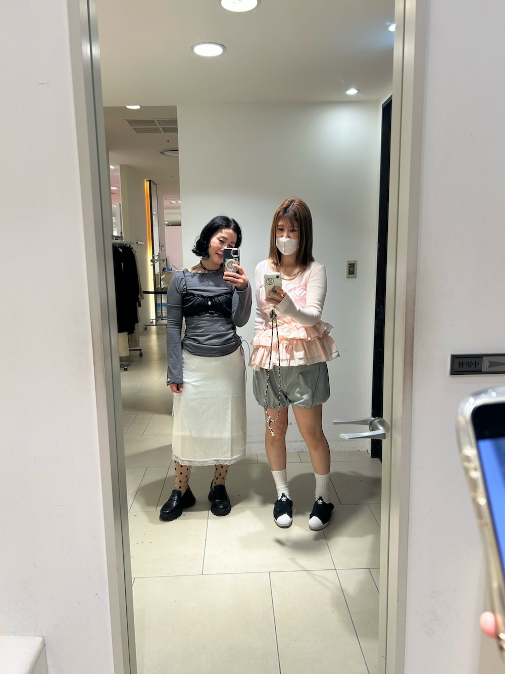 ホワイト系のTシャツ/カットソー、ホワイト系のスカート、ブラック系のローファーを着用したレディースの春コーディネートの2枚目の写真