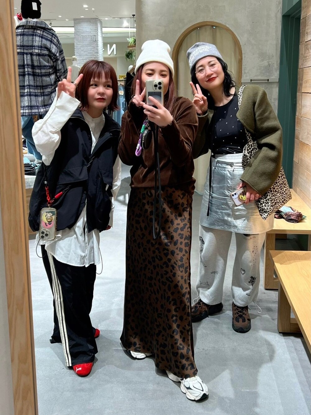 グリーン系のその他アウター、ホワイト系のTシャツ/カットソー、シルバー系のスカートを着用したレディースの冬コーディネートの2枚目の写真