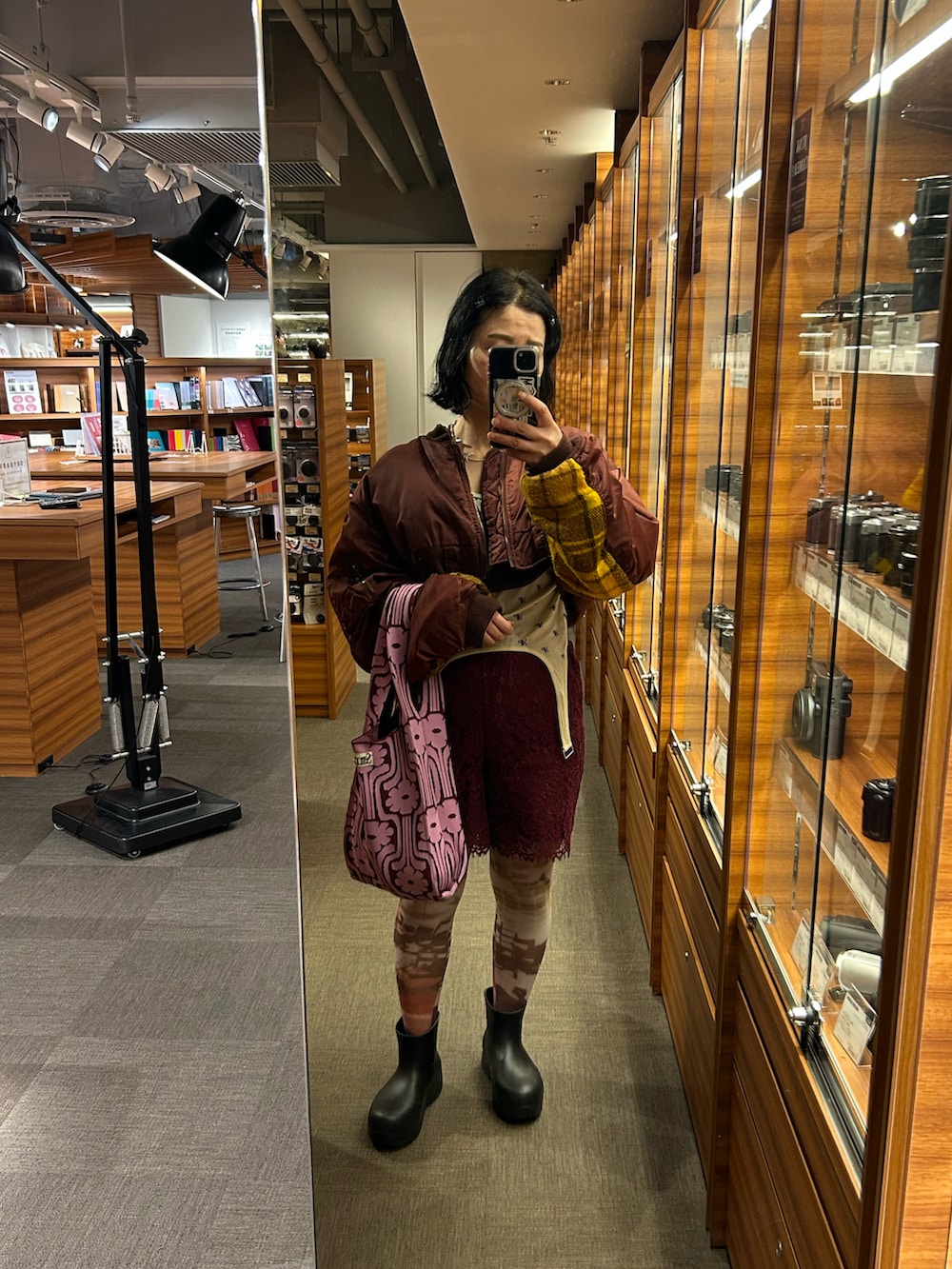 レッド系のその他パンツ、ブラック系のレインシューズ、その他のTシャツ/カットソーを着用したレディースの春コーディネートの2枚目の写真