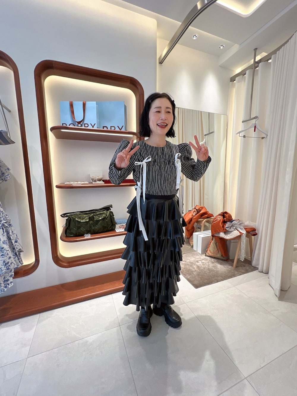 ブラック系のローファー、ホワイト系のTシャツ/カットソー、ブラック系のスカートを着用したレディースの冬コーディネートの3枚目の写真