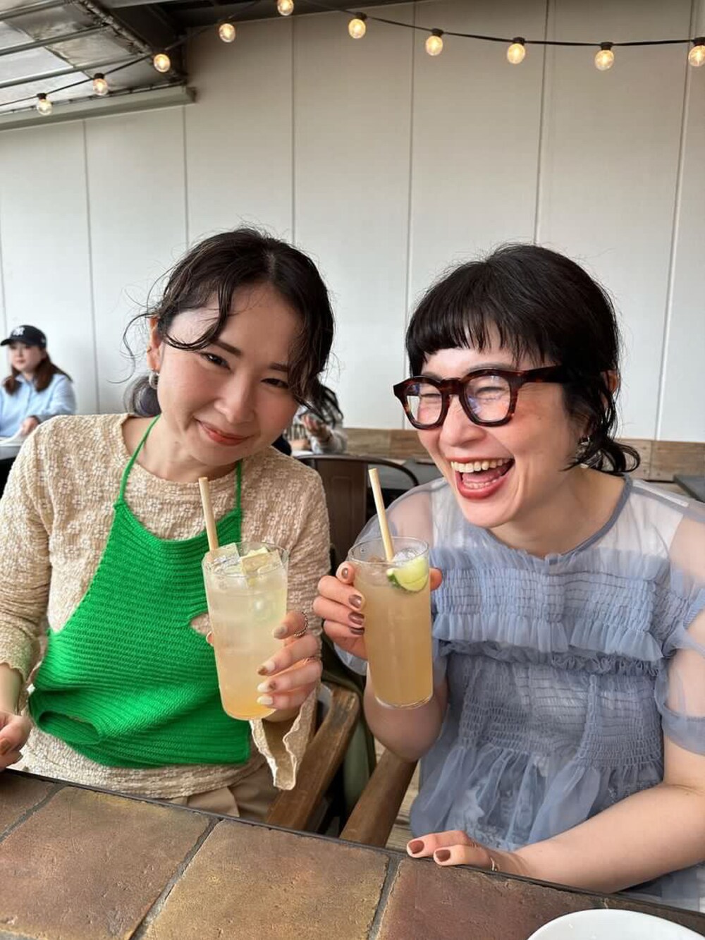 グレー系のノーカラージャケット、ホワイト系のワンピース、シルバー系のショルダーバッグを着用したレディースの春コーディネートの5枚目の写真