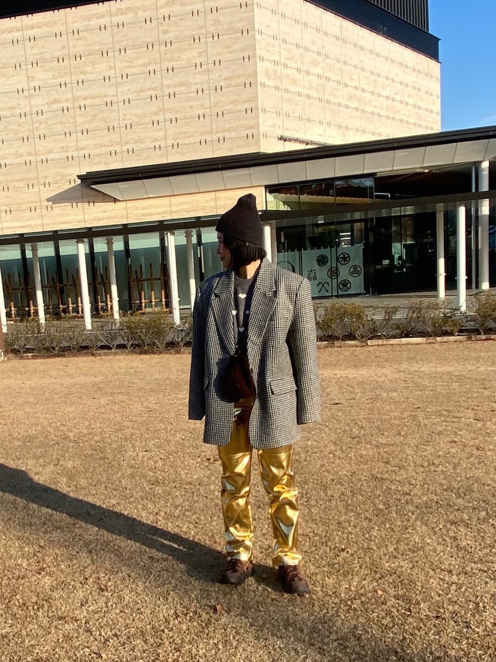 グレー系のテーラードジャケット、グレー系のニット/セーター、ゴールド系のその他パンツを着用したレディースの冬コーディネートの2枚目の写真