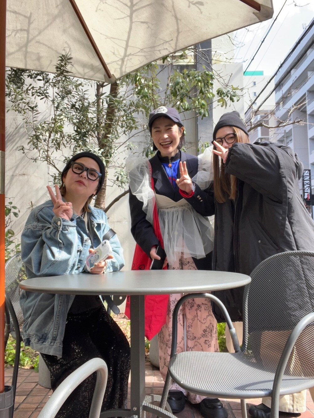 ベージュ系のベスト、ブラック系のテーラードジャケット、ブルー系のTシャツ/カットソーを着用したレディースの春コーディネートの3枚目の写真