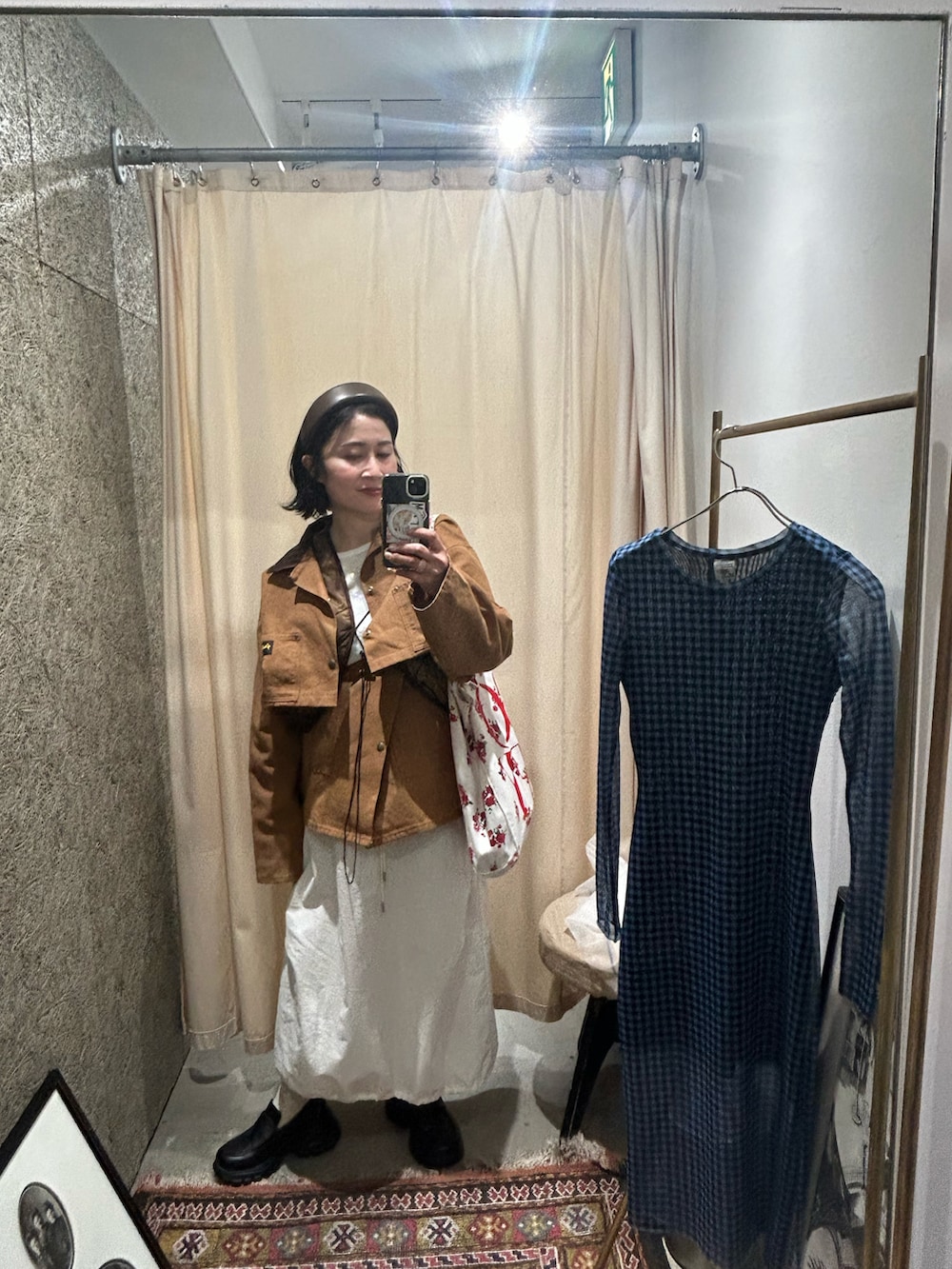 ブラック系のローファー、ホワイト系のスカート、ブラウン系のベストを着用したレディースの冬コーディネートの2枚目の写真