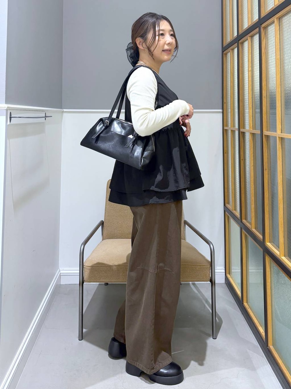 ブラック系のサンダル、ブラック系のボストンバッグ、ホワイト系のTシャツ/カットソーを着用したレディースの春コーディネートの5枚目の写真