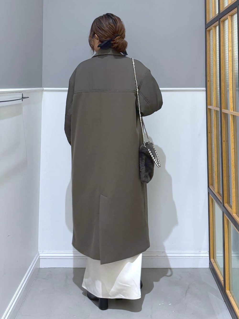 ホワイト系のスカート、ブラック系のブーツ、グレー系のショルダーバッグを着用したレディースの秋コーディネートの4枚目の写真