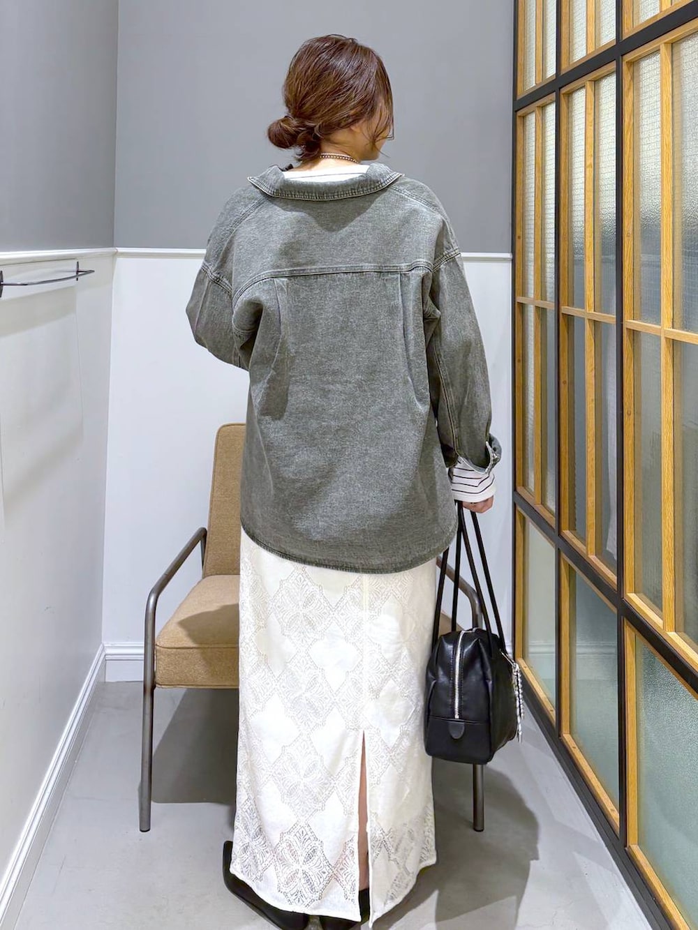 ブラック系のパンプス、グリーン系のシャツ/ブラウス、ホワイト系のスカートを着用したレディースの春コーディネートの4枚目の写真