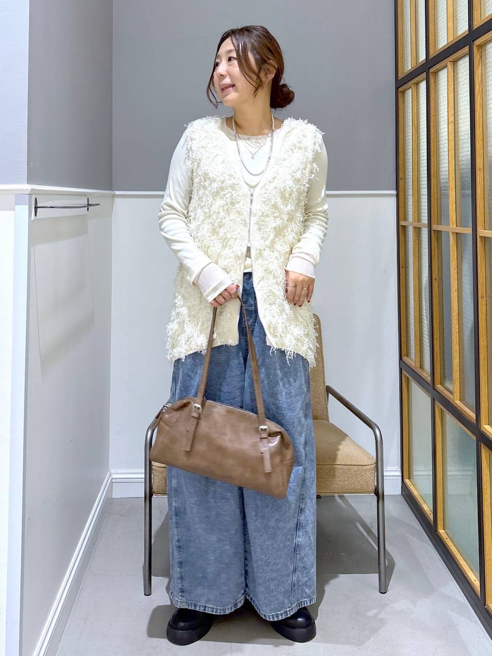 ブラック系のサンダル、ブラウン系のボストンバッグ、ホワイト系のTシャツ/カットソーを着用したレディースの冬コーディネートの5枚目の写真