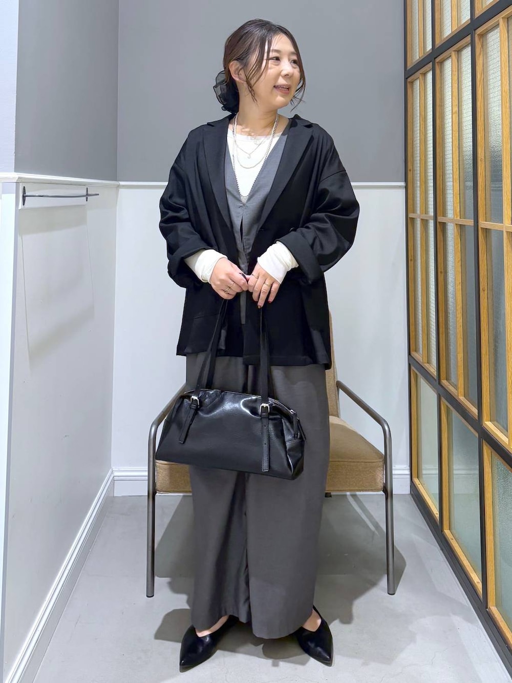 ブラック系のボストンバッグ、ホワイト系のTシャツ/カットソー、ブラック系のパンプスを着用したレディースの冬コーディネートの9枚目の写真