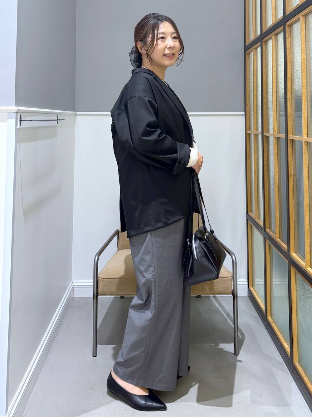 ブラック系のボストンバッグ、ホワイト系のTシャツ/カットソー、ブラック系のパンプスを着用したレディースの冬コーディネートの8枚目の写真