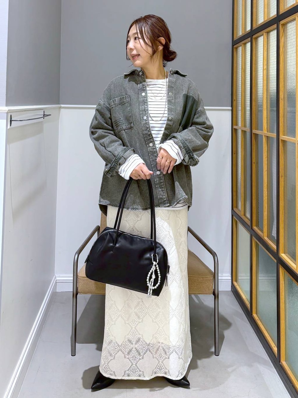 ブラック系のパンプス、グリーン系のシャツ/ブラウス、ホワイト系のスカートを着用したレディースの春コーディネートの2枚目の写真