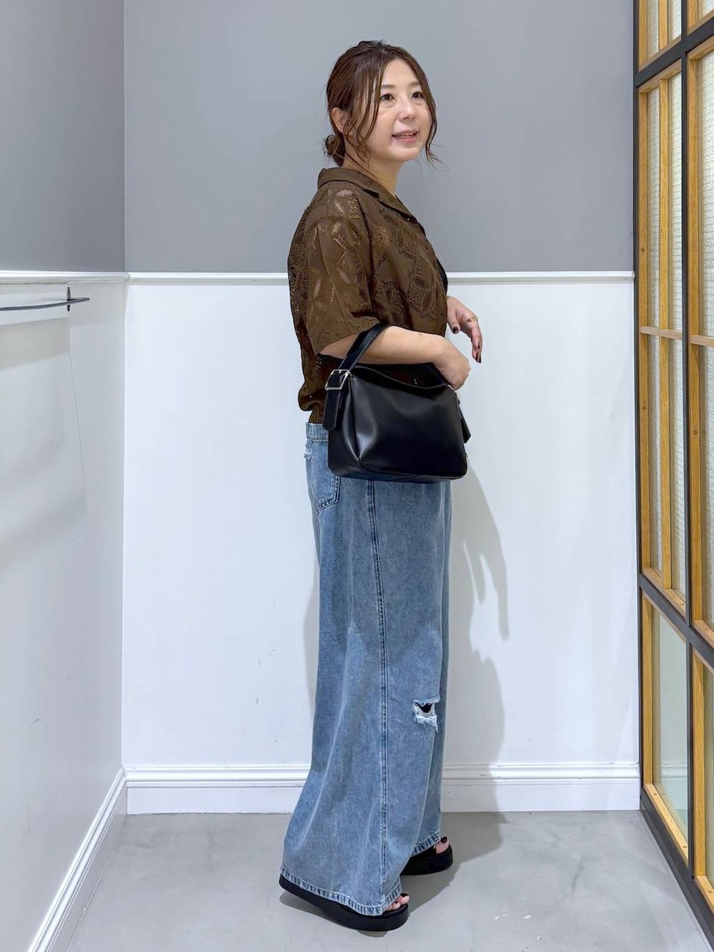 ブラウン系のシャツ/ブラウス、ブルー系のデニムパンツ、ブラック系のショルダーバッグを着用したレディースの夏コーディネートの4枚目の写真