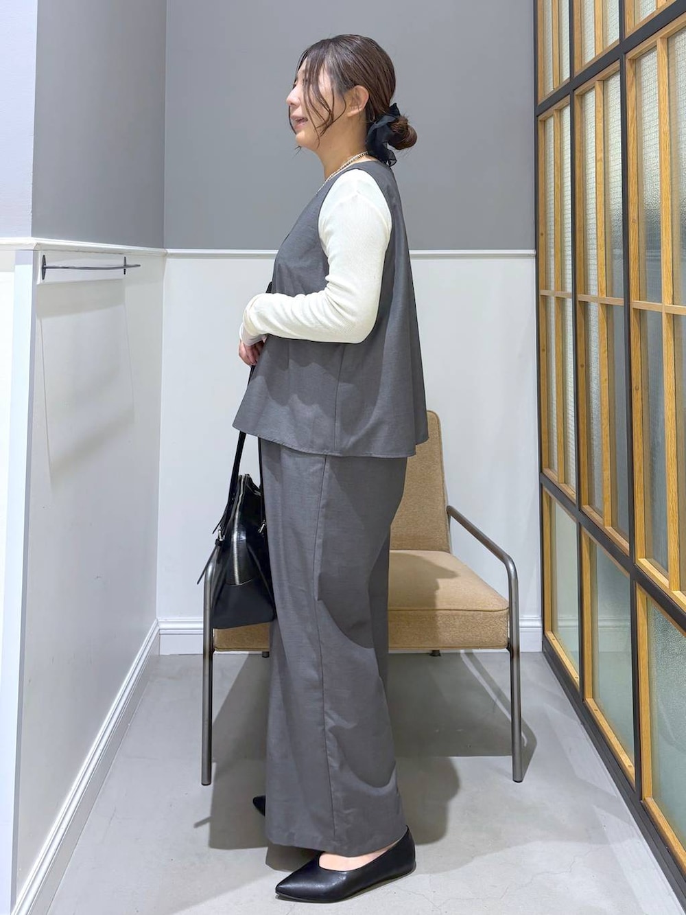 ブラック系のボストンバッグ、ホワイト系のTシャツ/カットソー、ブラック系のパンプスを着用したレディースの冬コーディネートの3枚目の写真