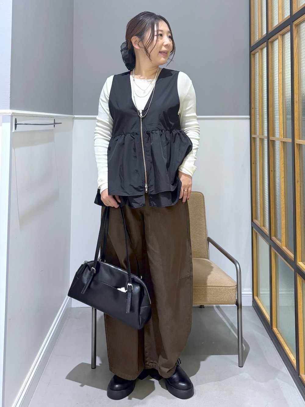 ブラック系のサンダル、ブラック系のボストンバッグ、ホワイト系のTシャツ/カットソーを着用したレディースの春コーディネートの2枚目の写真