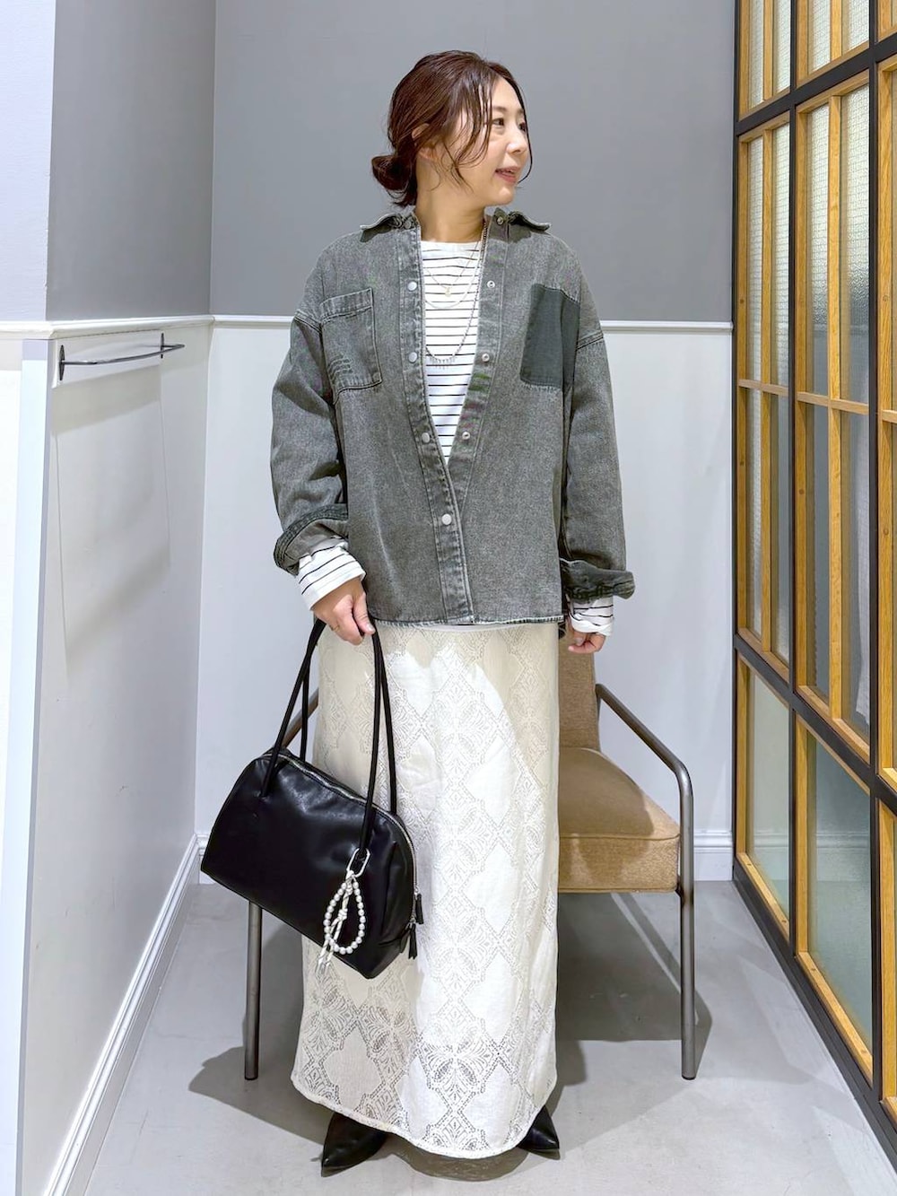 ブラック系のパンプス、グリーン系のシャツ/ブラウス、ホワイト系のスカートを着用したレディースの春コーディネートの6枚目の写真