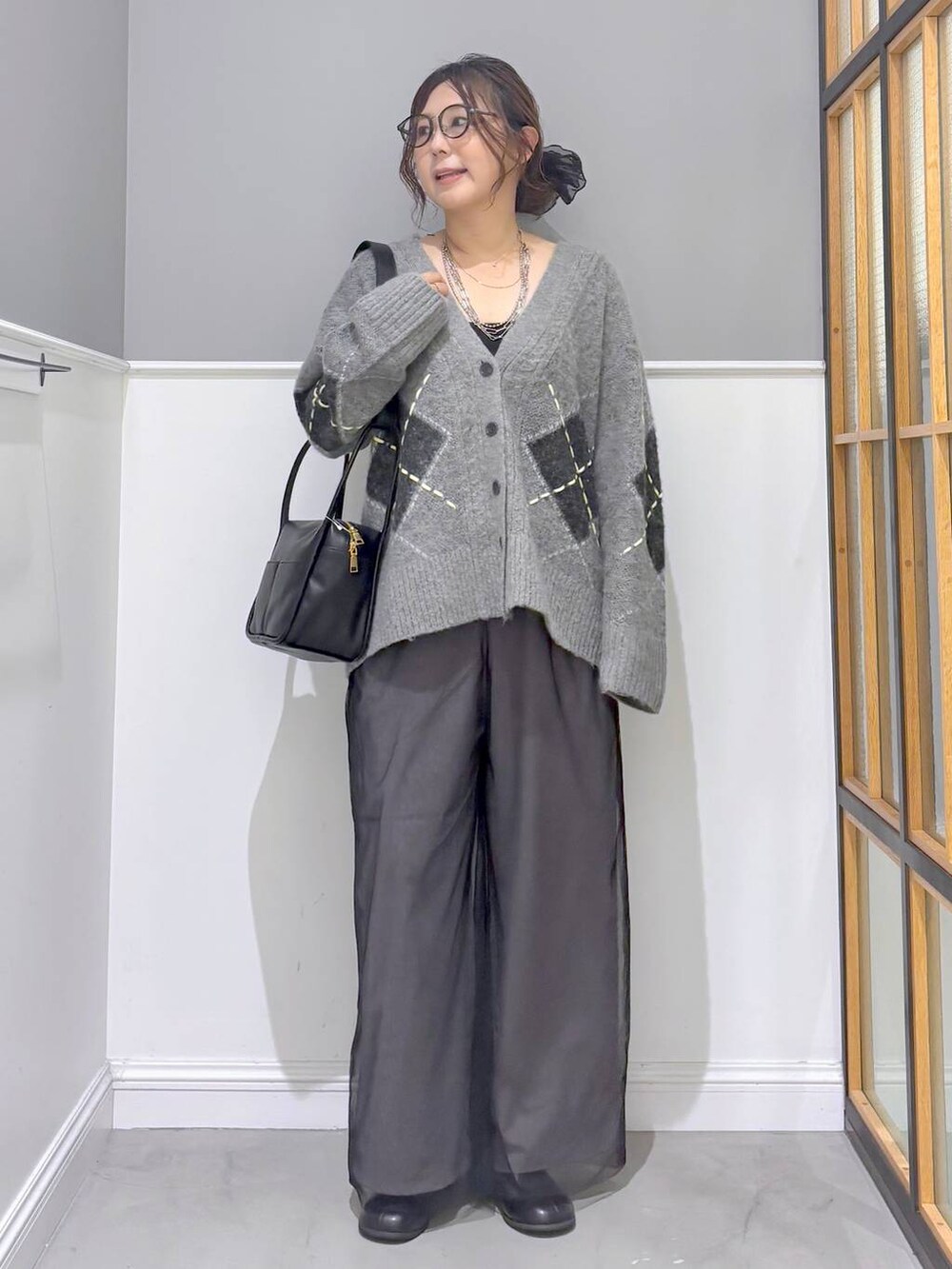 グレー系のその他パンツ、グレー系のカーディガン/ボレロ、ブラック系のブーツを着用したレディースの秋コーディネートの5枚目の写真