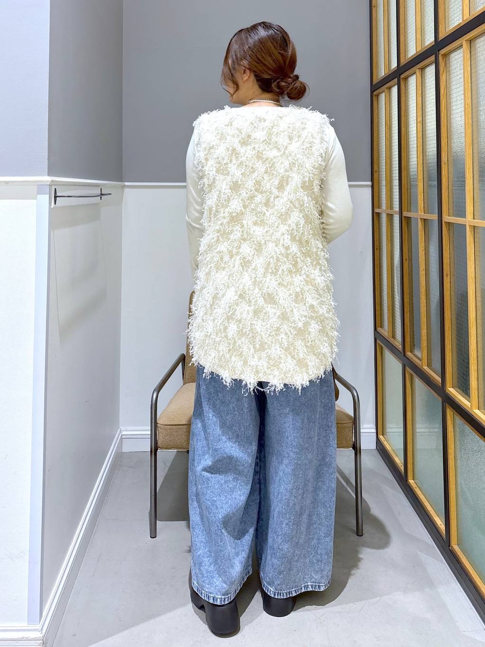 ブラック系のサンダル、ブラウン系のボストンバッグ、ホワイト系のTシャツ/カットソーを着用したレディースの冬コーディネートの3枚目の写真