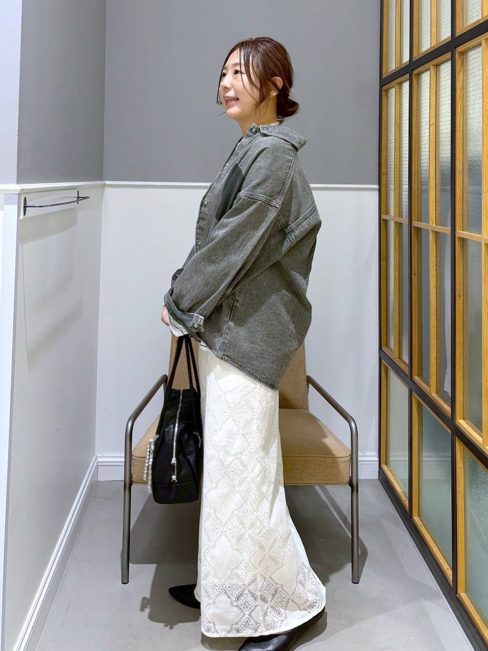 ブラック系のパンプス、グリーン系のシャツ/ブラウス、ホワイト系のスカートを着用したレディースの春コーディネートの3枚目の写真