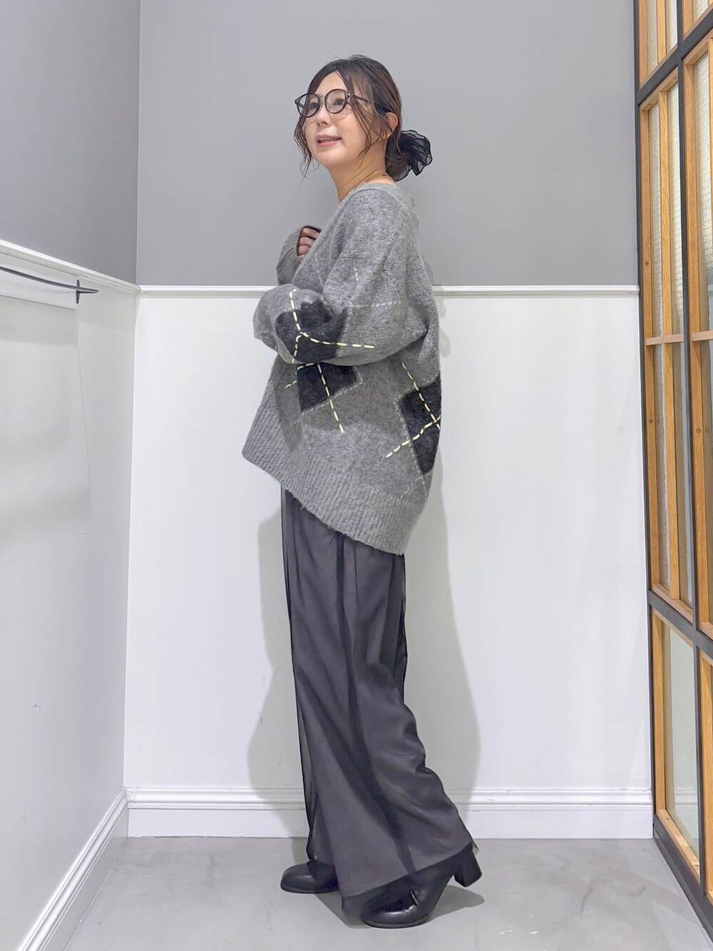 グレー系のその他パンツ、グレー系のカーディガン/ボレロ、ブラック系のブーツを着用したレディースの秋コーディネートの2枚目の写真