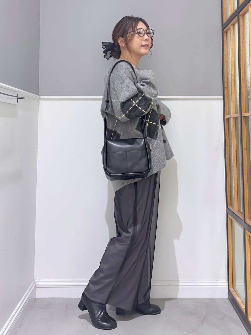 グレー系のその他パンツ、グレー系のカーディガン/ボレロ、ブラック系のブーツを着用したレディースの秋コーディネートの4枚目の写真