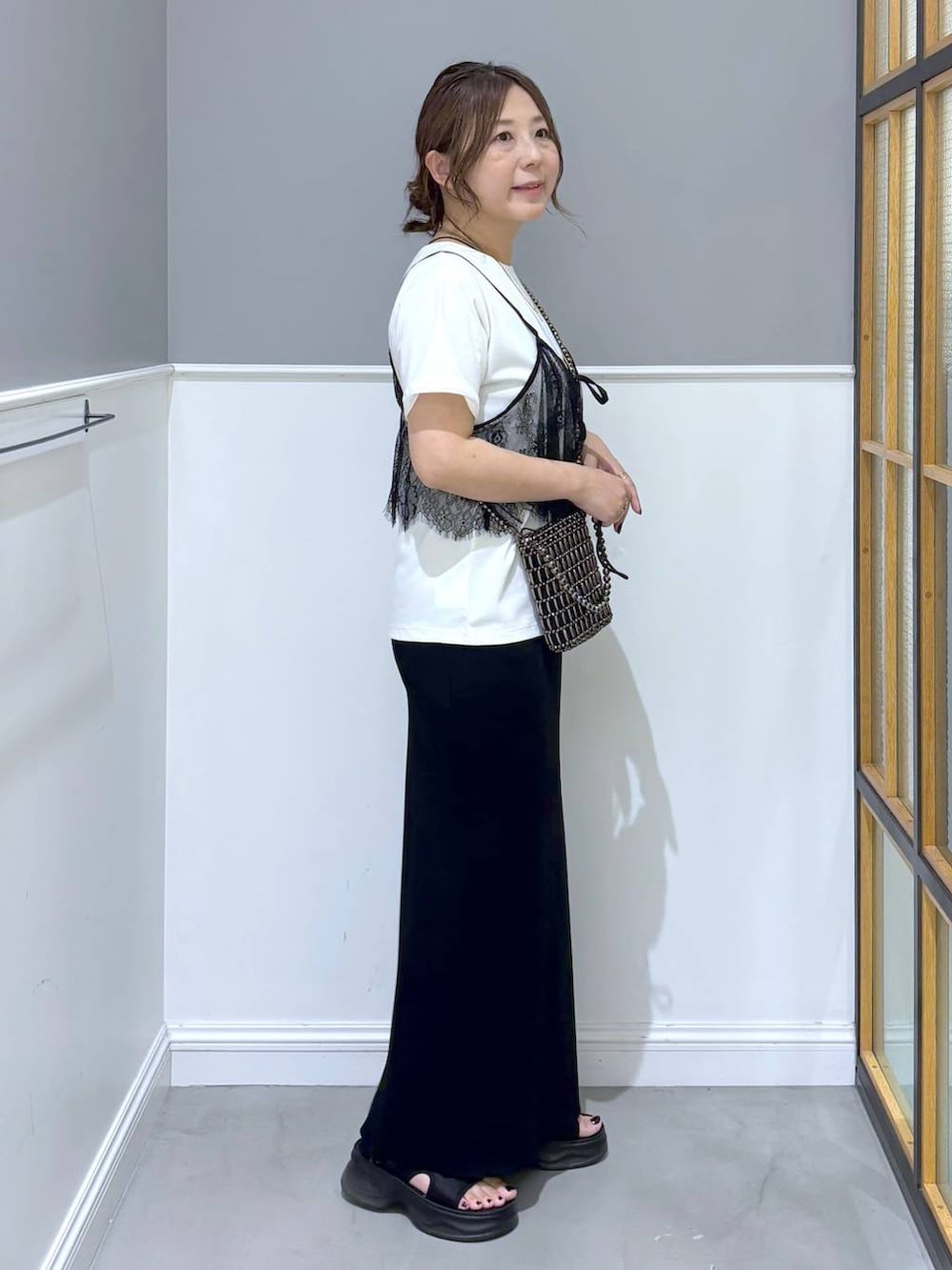 ブラック系のスカート、ブラック系のサンダル、その他のショルダーバッグを着用したレディースの夏コーディネートの4枚目の写真