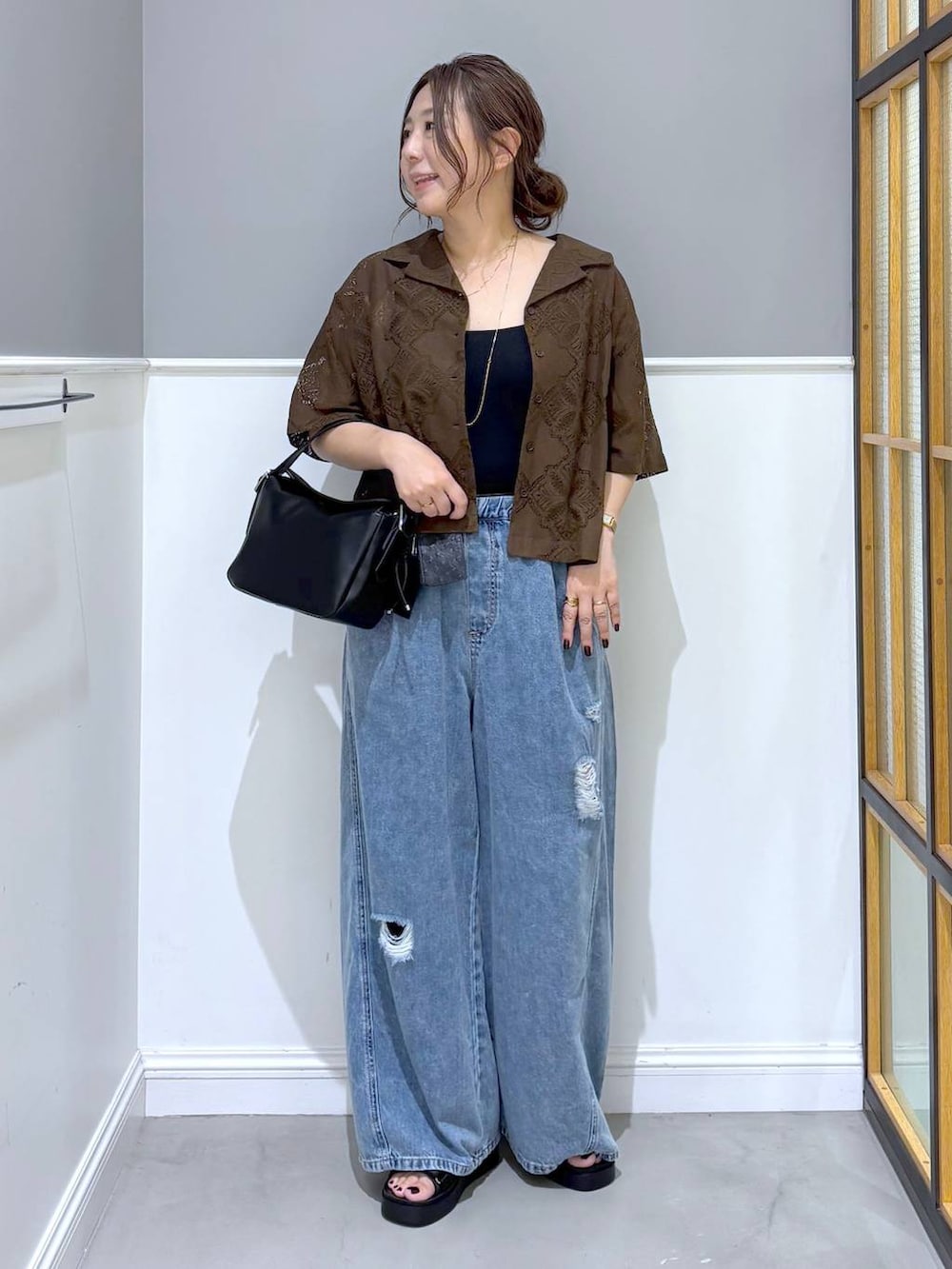 ブラウン系のシャツ/ブラウス、ブルー系のデニムパンツ、ブラック系のショルダーバッグを着用したレディースの夏コーディネートの5枚目の写真