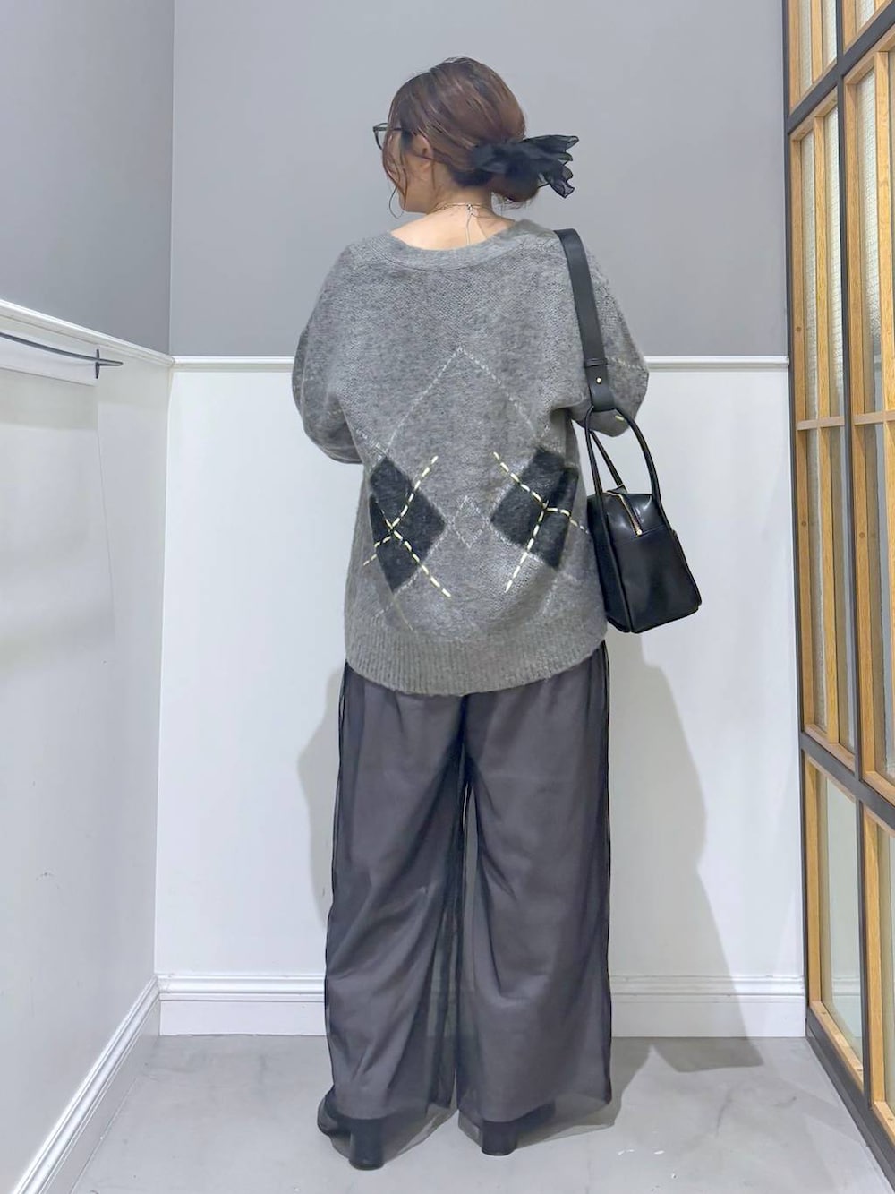 グレー系のその他パンツ、グレー系のカーディガン/ボレロ、ブラック系のブーツを着用したレディースの秋コーディネートの3枚目の写真