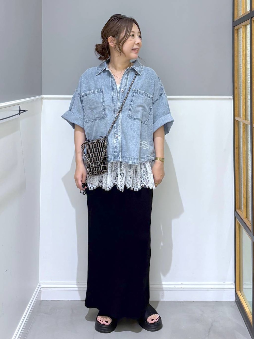 ブラック系のスカート、ブラック系のサンダル、ホワイト系のキャミソールを着用したレディースの夏コーディネートの5枚目の写真