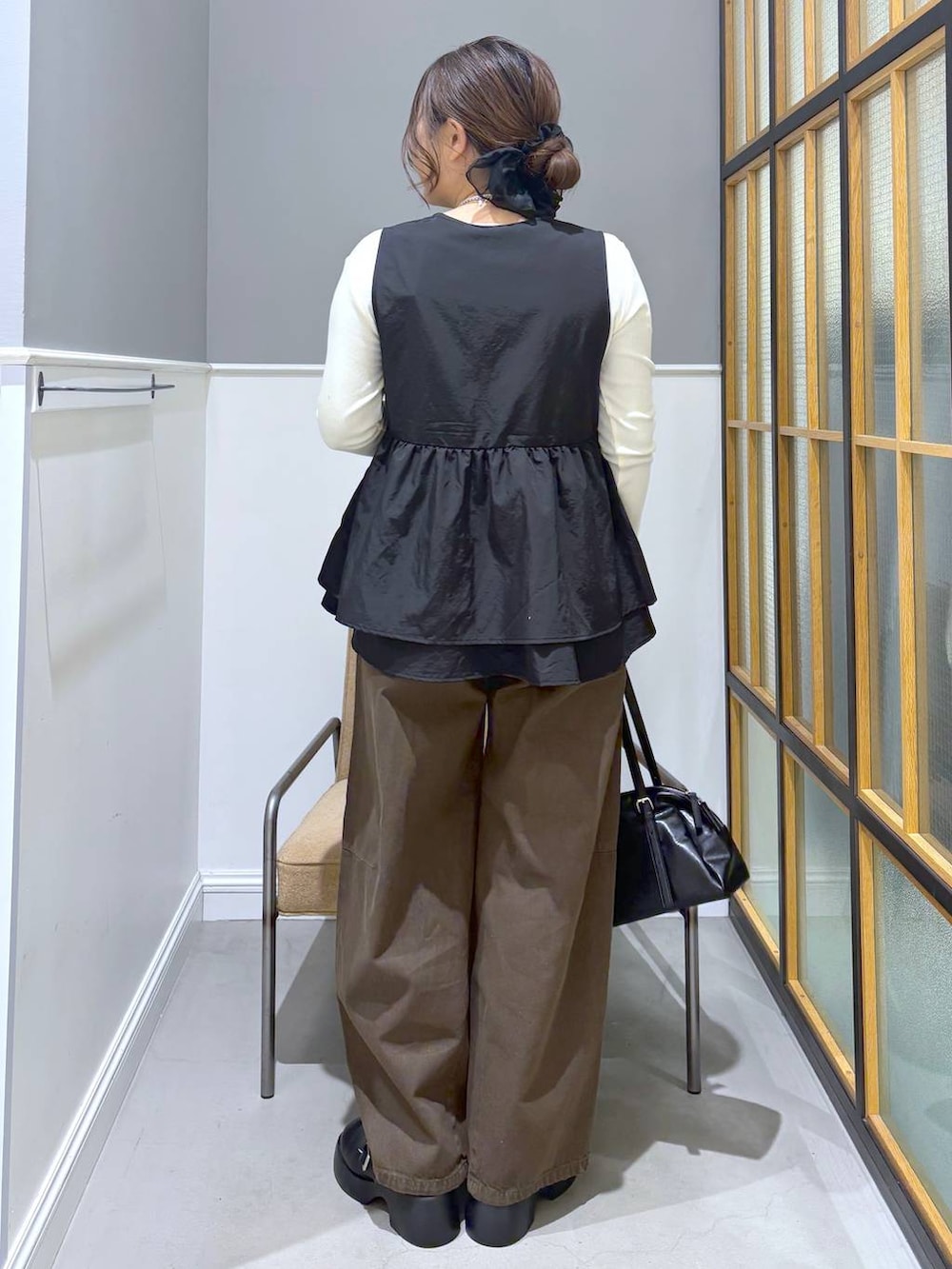 ブラック系のサンダル、ブラック系のボストンバッグ、ホワイト系のTシャツ/カットソーを着用したレディースの春コーディネートの4枚目の写真