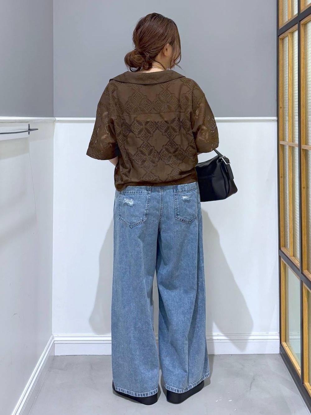 ブラウン系のシャツ/ブラウス、ブルー系のデニムパンツ、ブラック系のショルダーバッグを着用したレディースの夏コーディネートの3枚目の写真