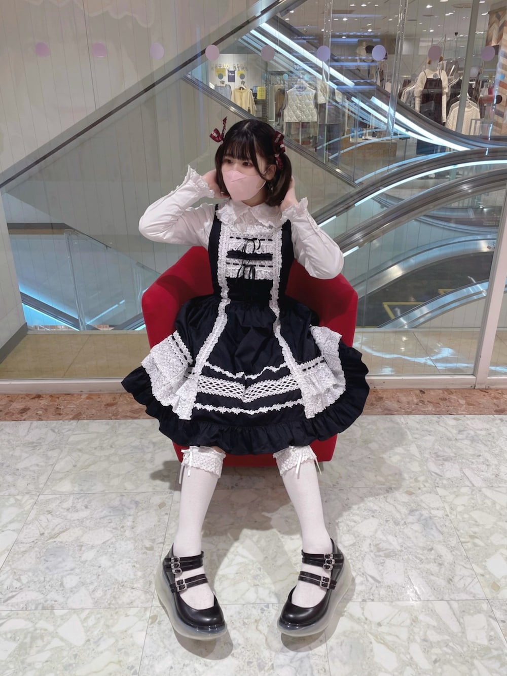 ホワイト系のその他アウター、ブラック系のジャンパースカート、ブラック系のシューズを着用したレディースの秋コーディネートの2枚目の写真