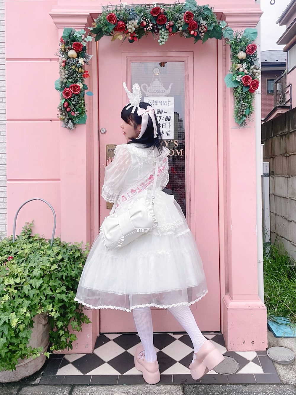 ピンク系のパンプス、ホワイト系のワンピース/ドレス、ホワイト系のショルダーバッグを着用したレディースの夏コーディネートの2枚目の写真