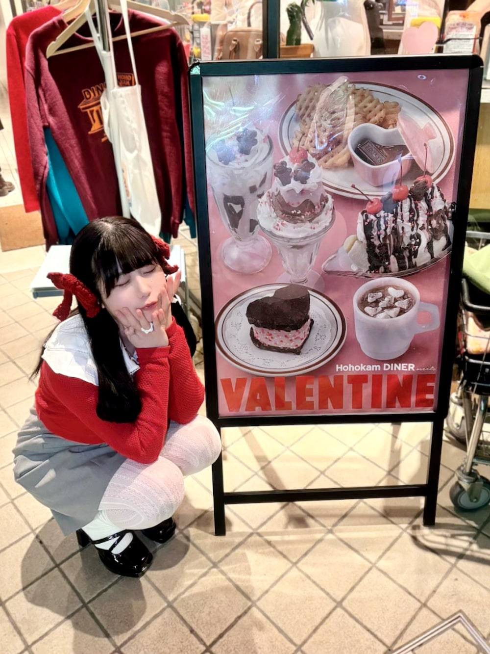 グレー系のワンピース、ブラック系のハンドバッグ、ブラック系のパンプスを着用したレディースの冬コーディネートの2枚目の写真