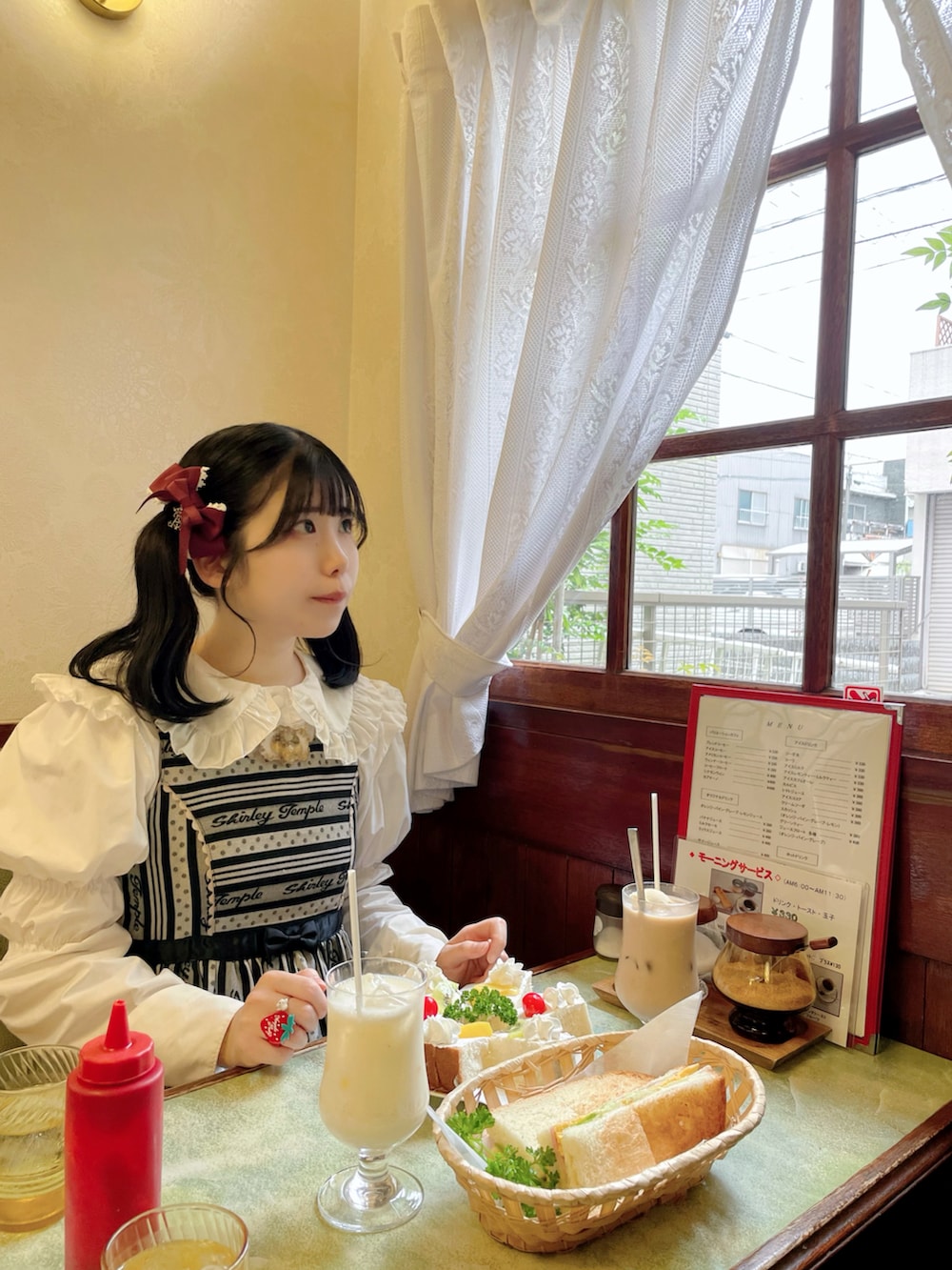 ピンク系のショルダーバッグ、ブラック系のバレエシューズ、ブラック系のジャンパースカートを着用したレディースの春コーディネートの2枚目の写真