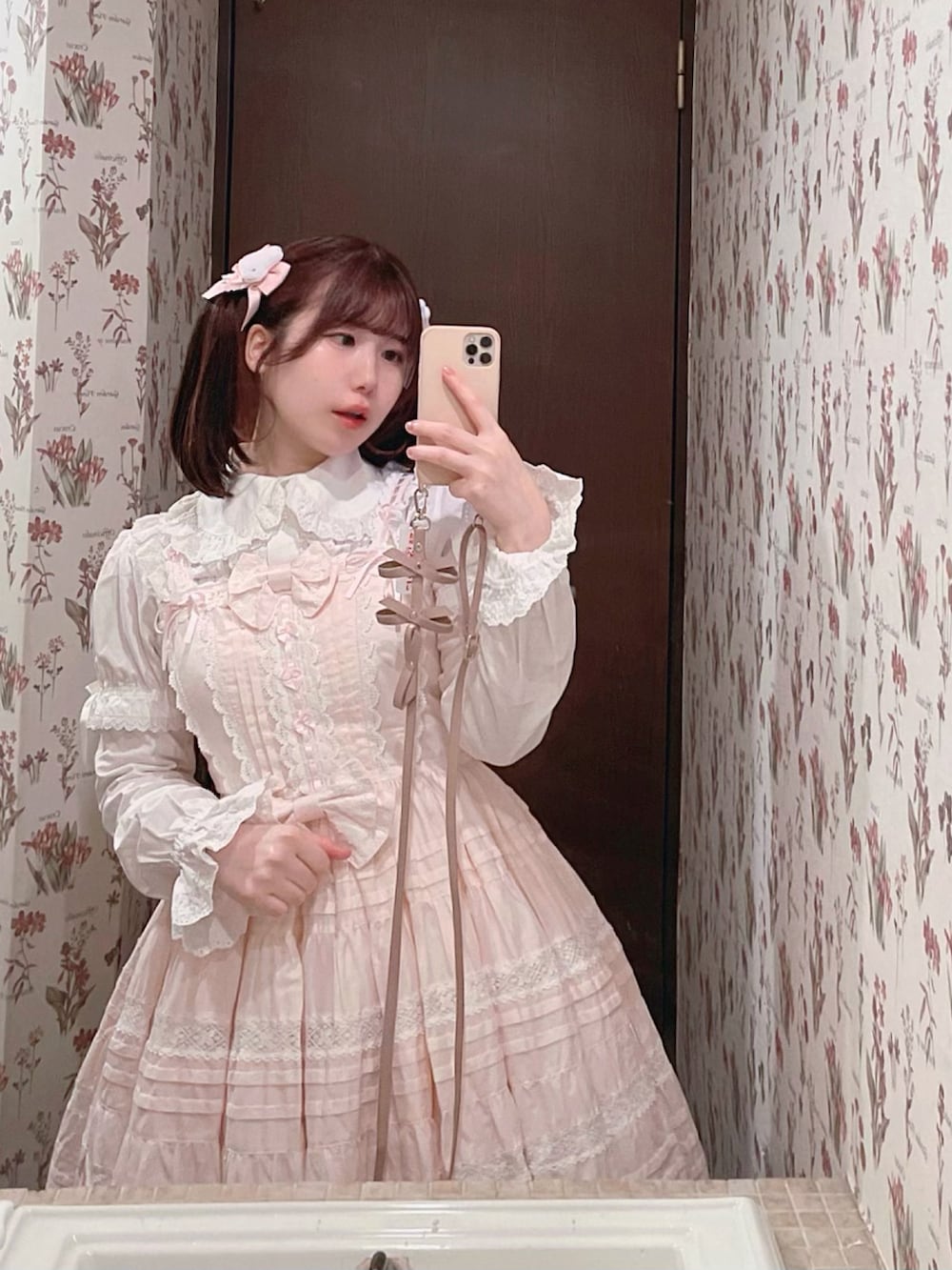 ピンク系のワンピース/ドレス、ピンク系のその他アウター、ブラウン系のバッグを着用したレディースの冬コーディネートの2枚目の写真