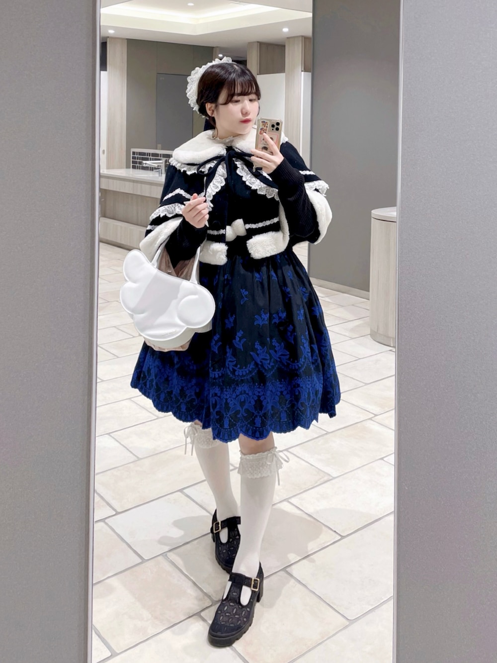 ブラック系のジャンパースカート、ブラック系のカーディガン/ボレロ、ブラック系のドレスシューズを着用したレディースの春コーディネートの2枚目の写真