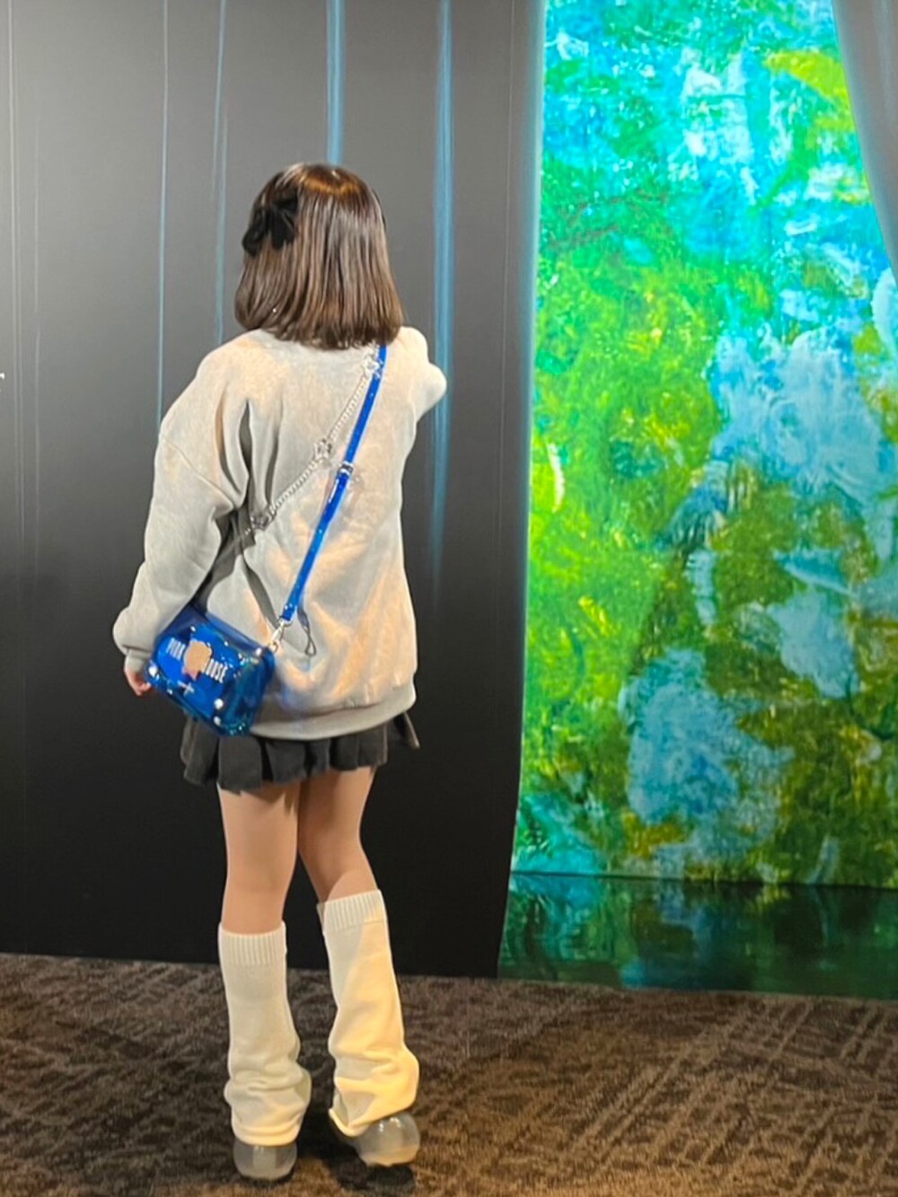 グレー系のTシャツ/カットソー、ブラック系のシューズ、ブルー系のショルダーバッグを着用したレディースの秋コーディネートの2枚目の写真