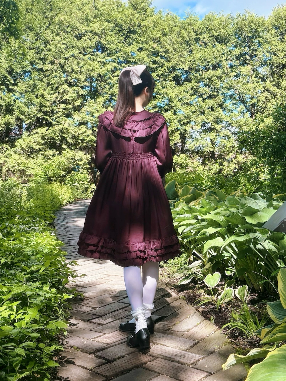 レッド系のワンピース/ドレス、ブラック系のシューズ、ピンク系のバレッタ/ヘアクリップを着用したレディースの秋コーディネートの2枚目の写真