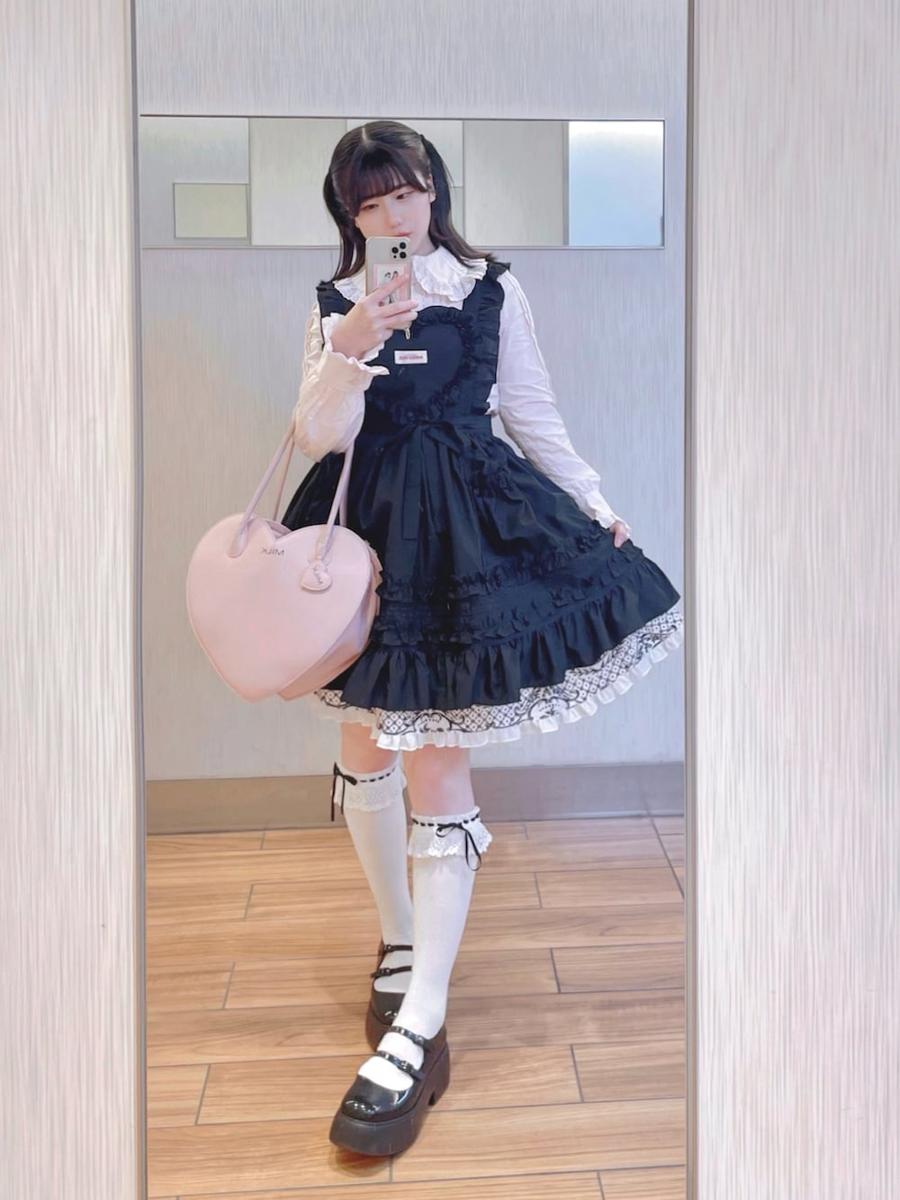 ブラック系のワンピース/ドレス、ブラック系のジャケット/アウター、ピンク系のハンドバッグを着用したレディースの冬コーディネートの2枚目の写真