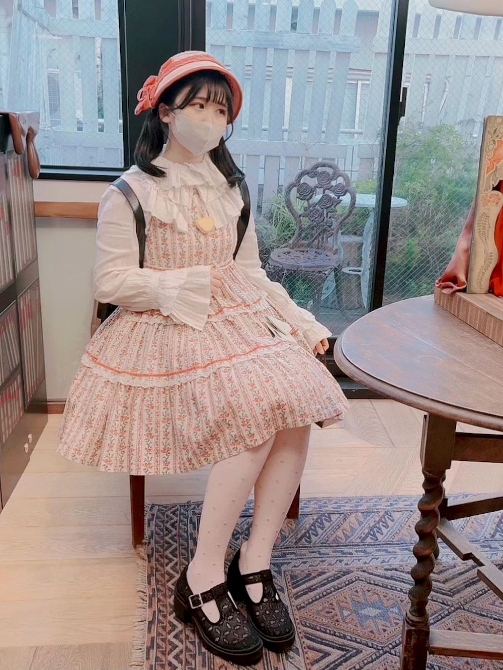 ピンク系のジャンパースカート、ベージュ系のシャツ/ブラウス、ブラック系のバックパック/リュックを着用したレディースの春コーディネートの2枚目の写真