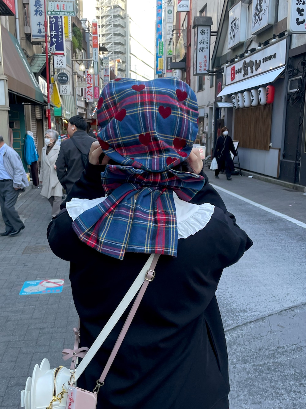 ブラック系のカーディガン/ボレロ、レッド系のスカート、ホワイト系のシャツ/ブラウスを着用したレディースの冬コーディネートの2枚目の写真