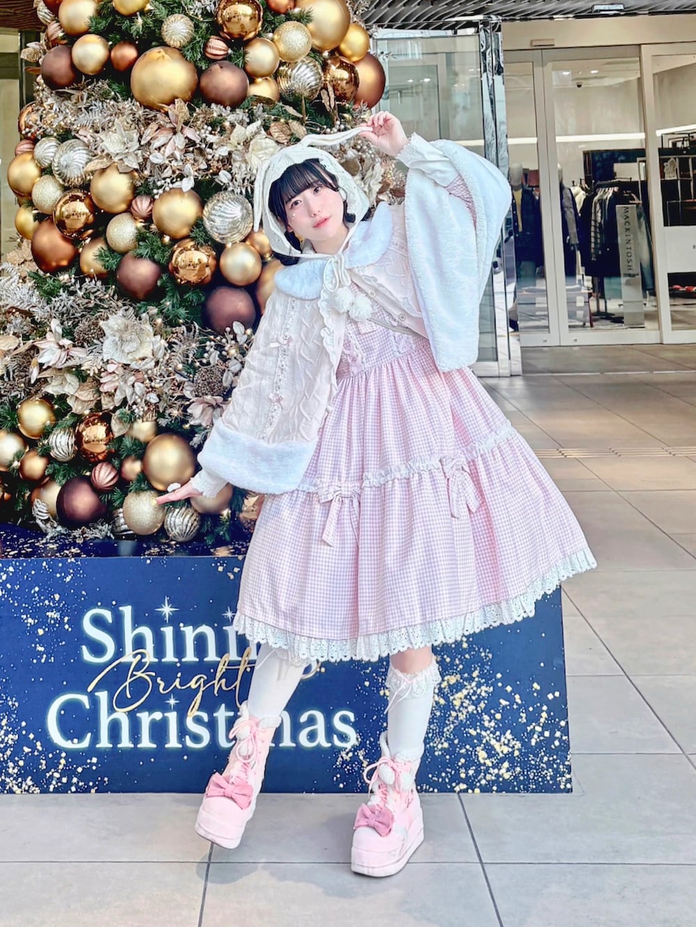 ピンク系のポンチョ、ピンク系のワンピース/ドレス、ホワイト系のバッグを着用したレディースの冬コーディネートの2枚目の写真