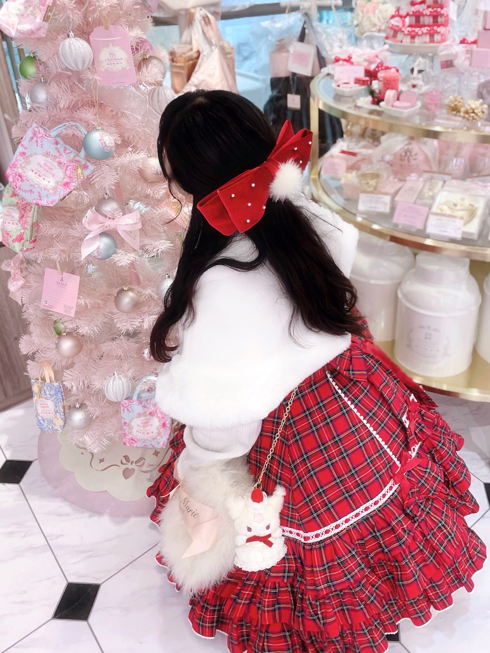 ホワイト系のニット/セーター、ホワイト系のその他アウター、ホワイト系のショルダーバッグを着用したレディースの冬コーディネートの2枚目の写真