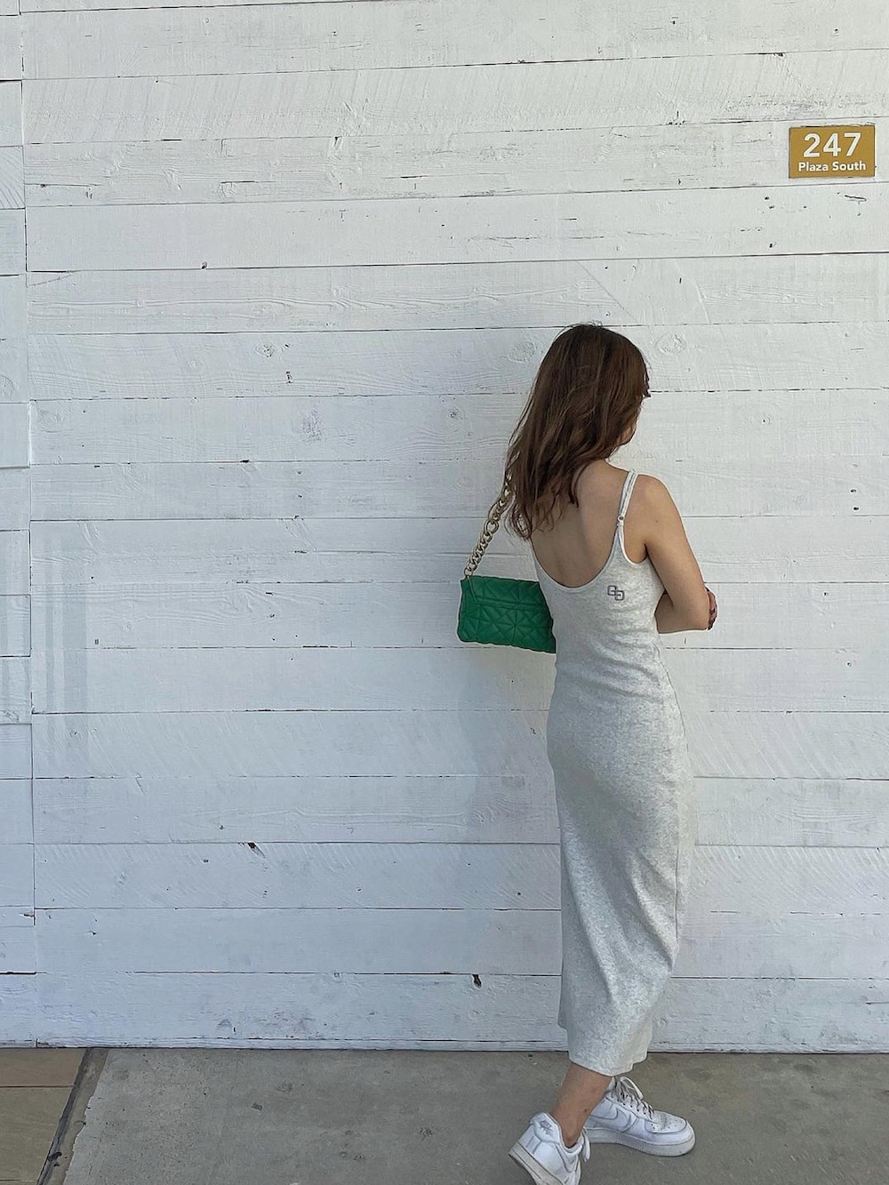 ホワイト系のスニーカー、ホワイト系のワンピース、グリーン系のショルダーバッグを着用したレディースの夏コーディネートの2枚目の写真