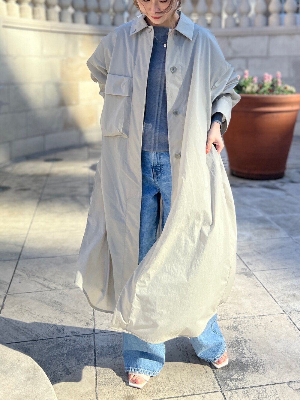 ベージュ系のその他アウター、グレー系のニット/セーター、ブルー系のデニムパンツを着用したレディースの冬コーディネートの6枚目の写真